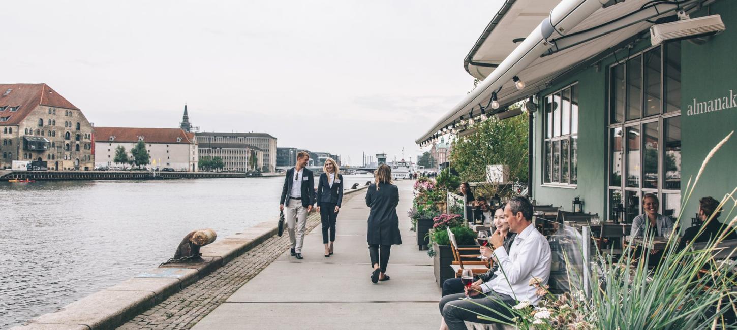 Personer holder gå-møde langs promenaden